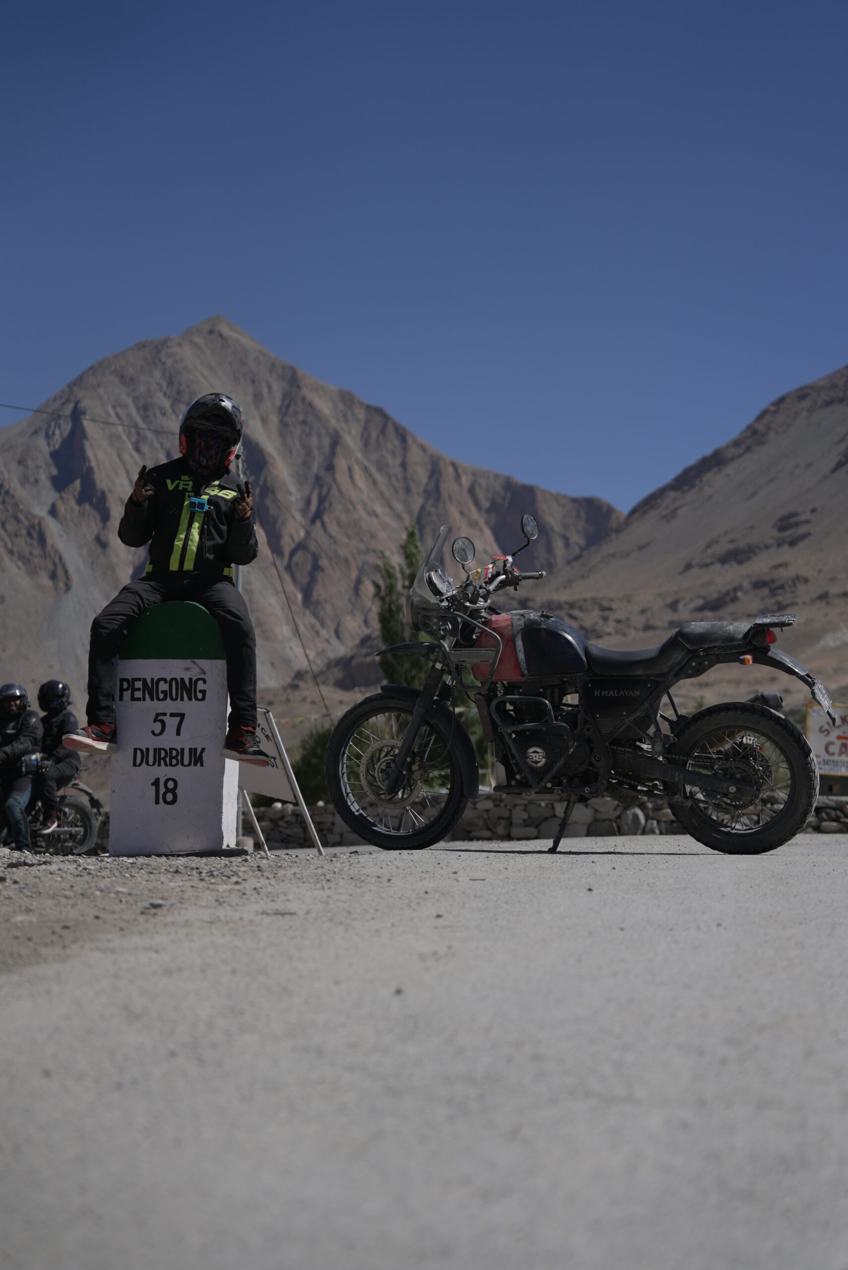 Adventure touring bikes parked outside mountain homestays under clear high-altitude skies